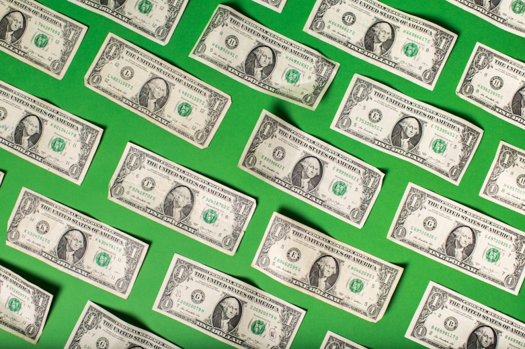 Rows of one-dollar bills arranged on a green background