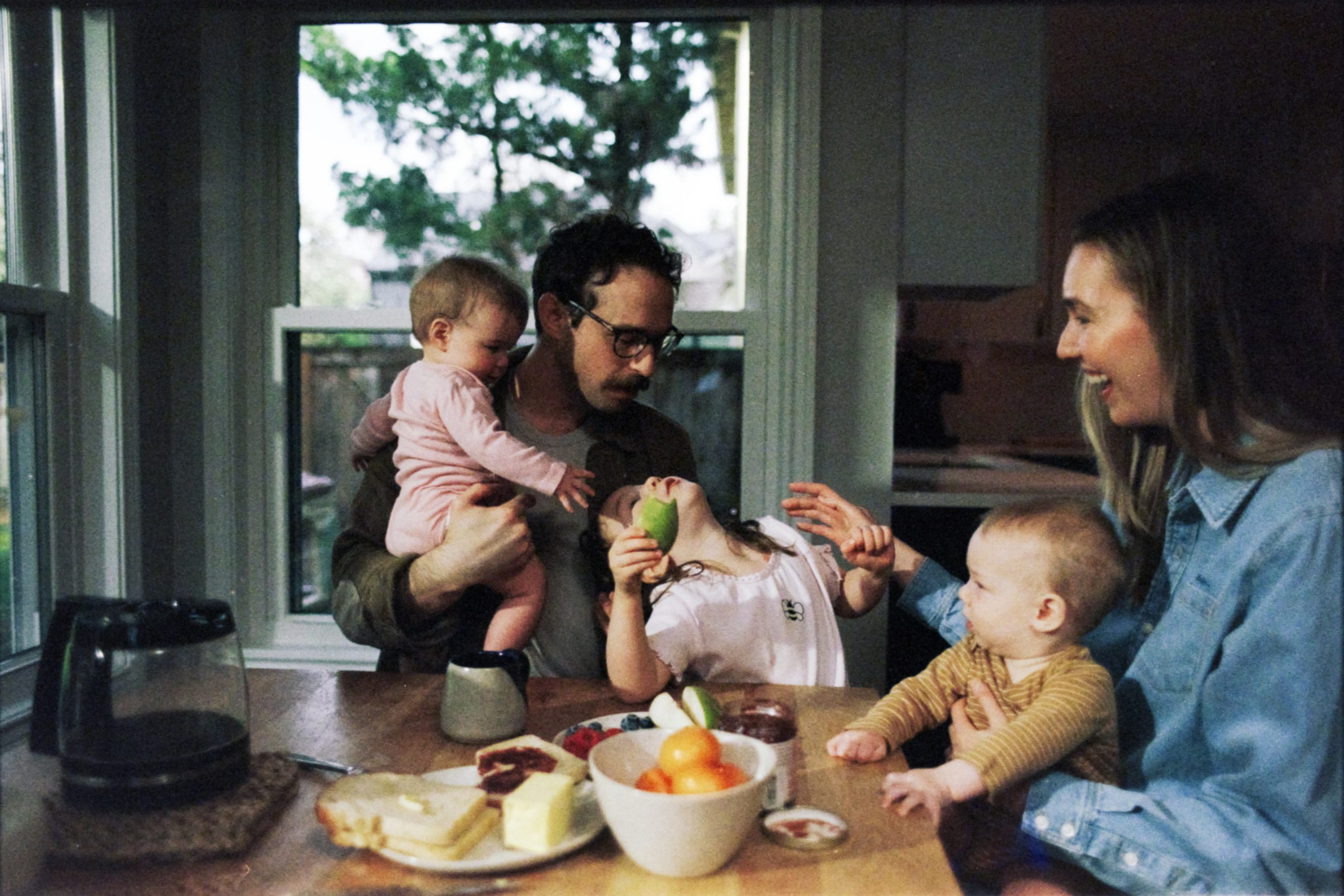 A family with two young children sharing breakfast at a kitchen table