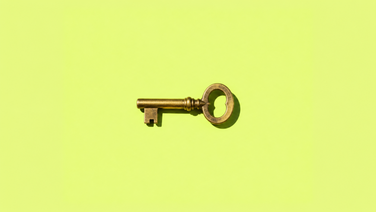 A small brass key on a lime green background